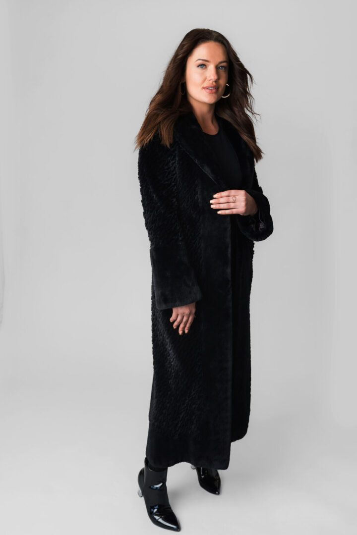 A Woman Wearing a Black Knee Length Velvet Coat